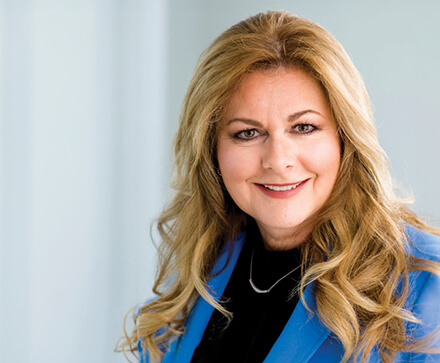 blonde woman with blue suit jacket and black top