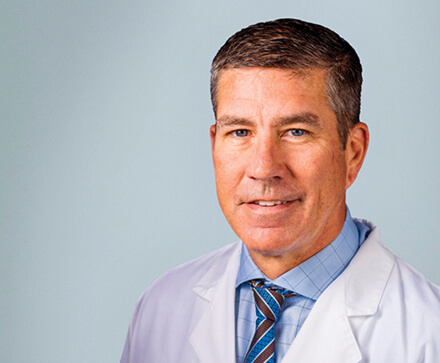 male physician in white lab coat and pale blue button shirt