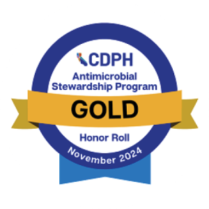Blue circle with gold ribbon saying CDPH Antimicrobial Stewardship Program Gold Honor Roll November 2025