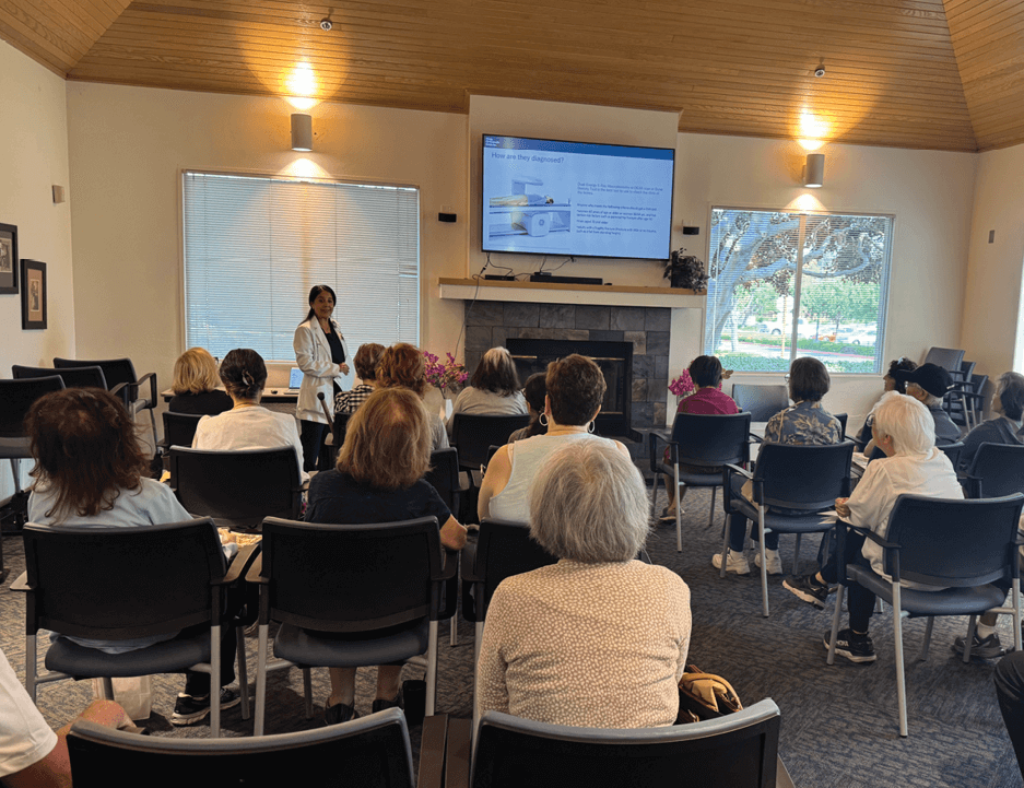 physician in a community meeting room with various attendees
