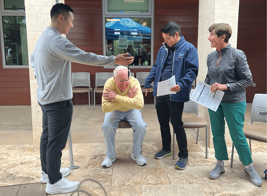physical therapy team with a senior male squatting
