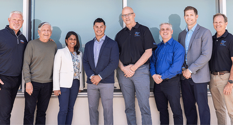 group photo of 8 men and women dressed in business casual
